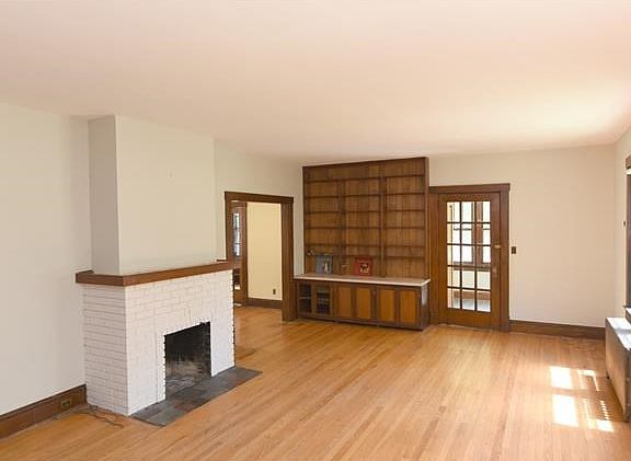 Front door into a small entry porch with closet.  French door leads to Living room with high ceilings, built in shelves and fireplace. Hardwood floors thru-out.