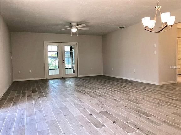 Living room with french doors out to the Florida Room, all new wood plank ceramic tile, all new lighting fixtures, freshly paint