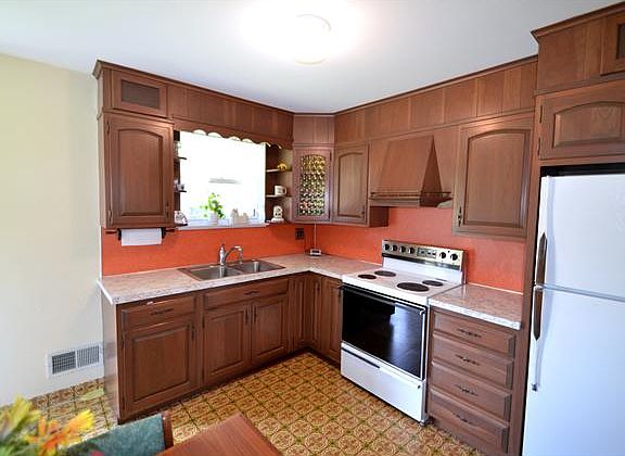 Kitchen features wood cabinetry & electric cooking