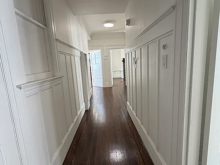 View from front door; 1st bedroom on the right, 1/2 bath/toilet on left just inside front door. Living room access is on right at the end of the hall and dining room is on the left.