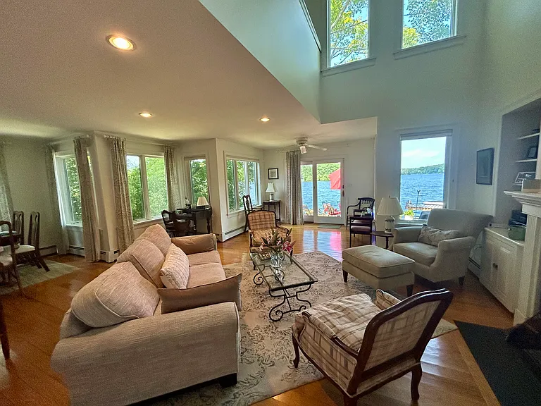 Open Concept Living and Dining Room with high-ceiling atrium to second story. Hardwood floors. Wood-burning stove. Lots of natural light and lake views from every angle.
