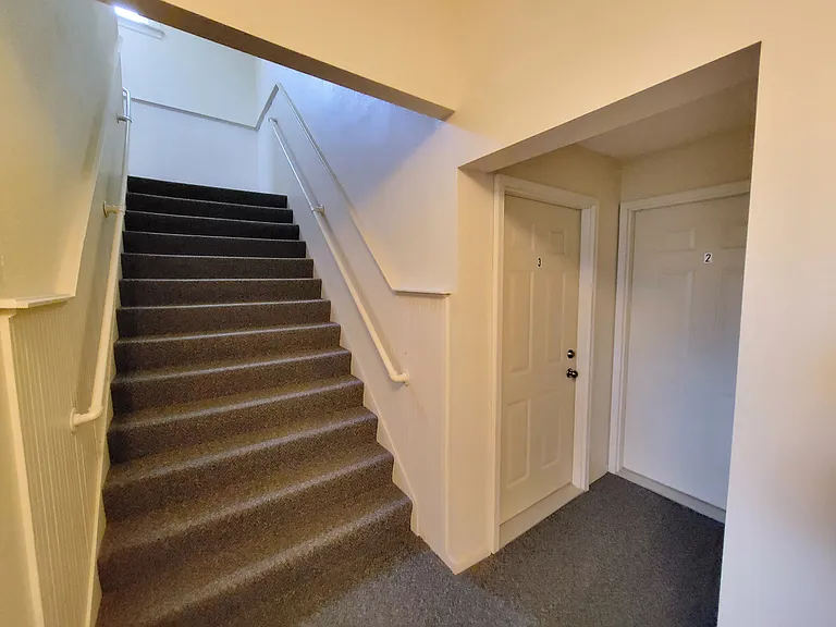 Stairs to upstairs units, white door on right is unit 2