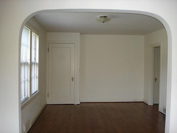 Living room showing inside apt with front door on left. Door on far right leads to small hall leading to stairs to basement, apt. laundry and exit to outside. Original doorknobs were re-brassed