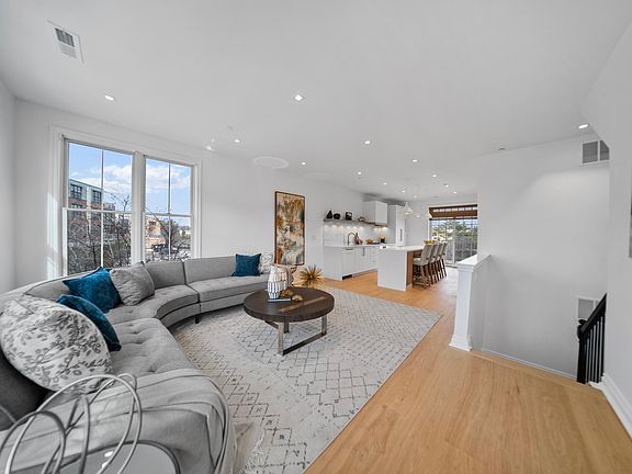 open concept living room and kitchen with small balcony off of kitchen