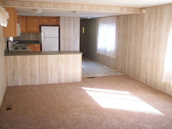 Looking from the living room to the kitchen. The hall leads to the laundry area (newer washer and dryer included) and one of the two bedrooms. Bedrooms are located at opposite ends of the home for maximum privacy.