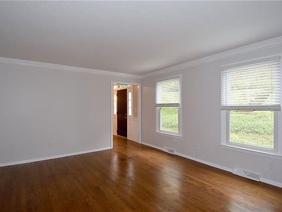The living room is detailed with crown molding.  Natural light flows into this space from the windows.