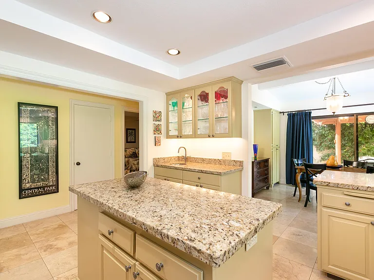Island counter for kitchen with view to breakfast room and crystal cabinet,