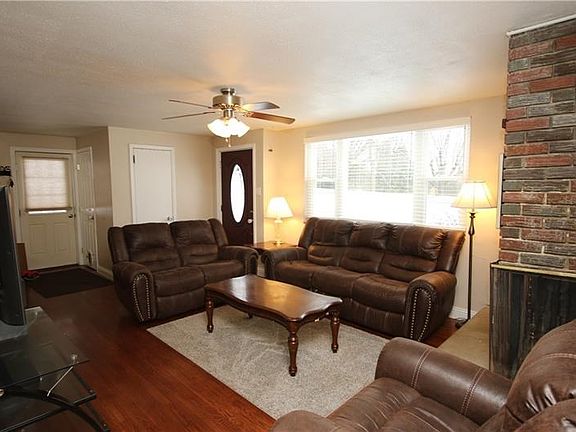 GORGEOUS Living Room hosting Beautiful Brick corner Gas Fireplace, Coat Closet & Plenty of Natural Sunlight Flowing Nicely thru-
