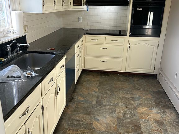 Kitchen with granite countertops, new cooktop, wall oven, dishwasher and flooring