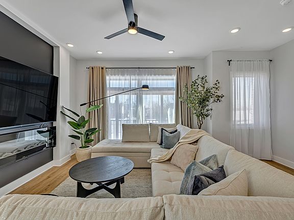Dining/Living area. 86" TV with soundbar, subwoofer, and wall electric fireplace