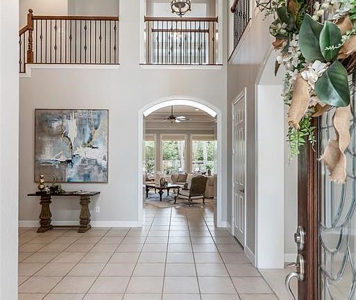 Grand two story entrance with a view through the family room out the patio and poo.