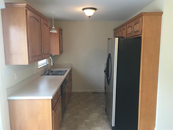 Kitchen includes attractive cabinets and modern fixture with stainless steel sink