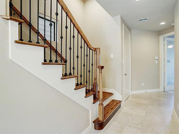 The wrought iron railing with wood treads lead up to the second level living area. The entrance leads to the first floor bedroom/office.