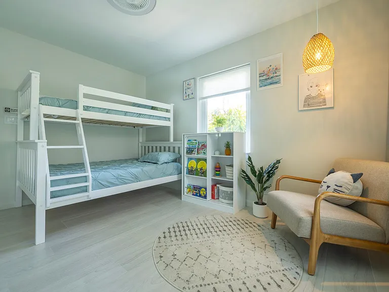 Kids bedroom with full size bunk bed (full size on the first level and twin size on the top level). Designer wall mural, toys.