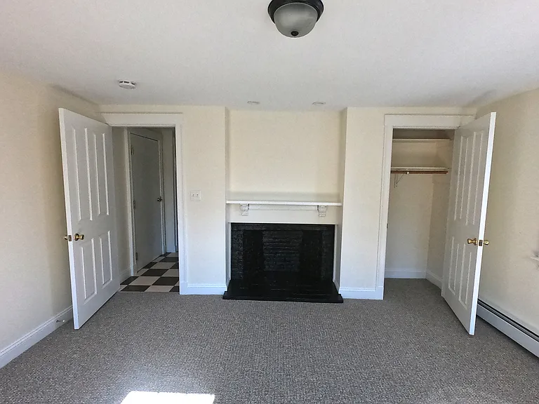 Bedroom, with decorative fireplace and closet.