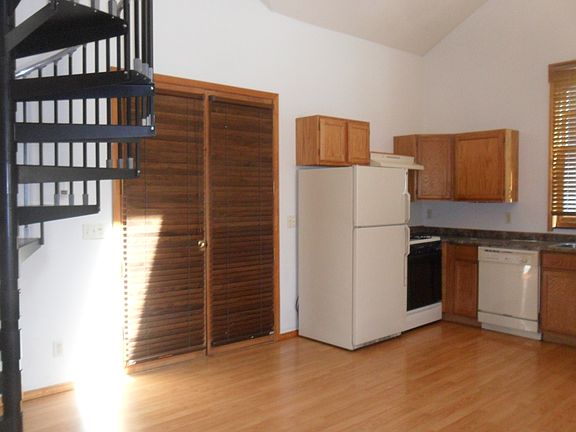 Entry door, kitchen, and circular stairs to the loft