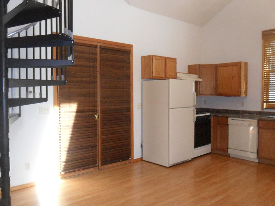 Entry door, kitchen, and circular stairs to the loft