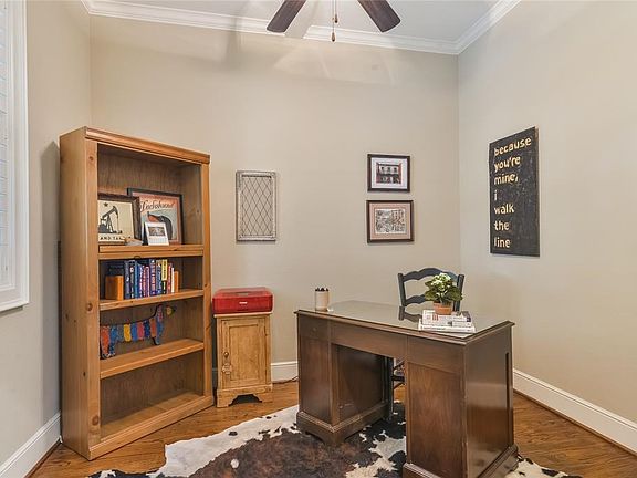 Study at front entry with pocket doors, gleaming hardwood floors, and plantation shutters.