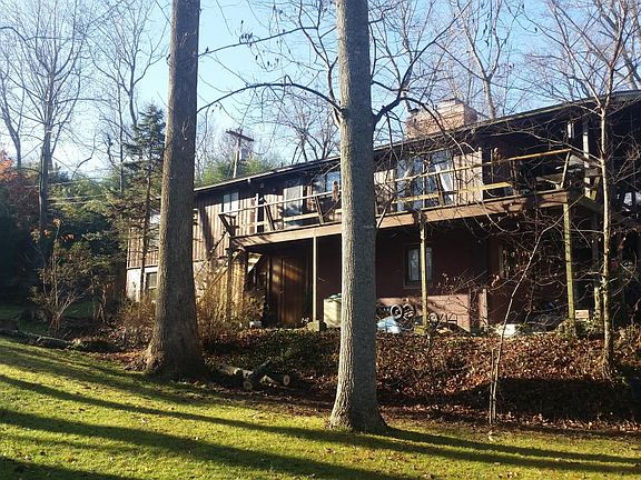 Back of home with large wrapping deck with seating for 10.