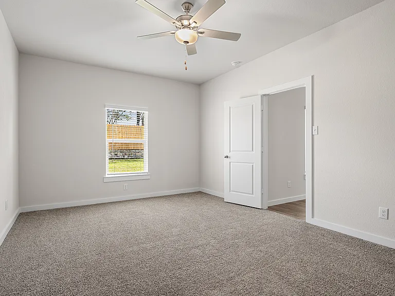 The spacious master bedroom has a window that lets in great, natural light and backyard views.