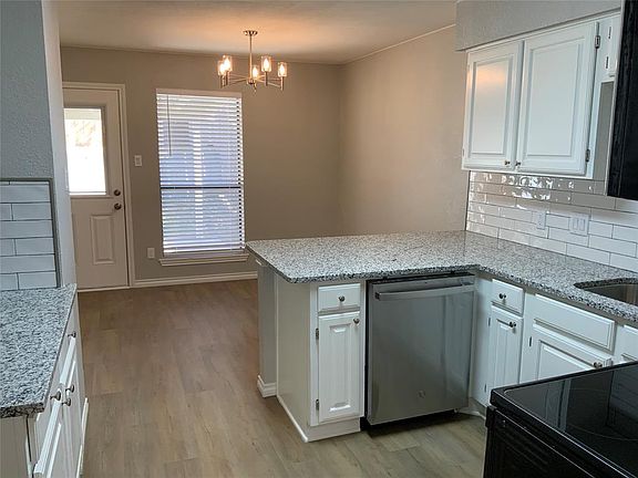 Kitchen with dishwasher, light wood-style flooring, black electric range oven, and white cabinetry