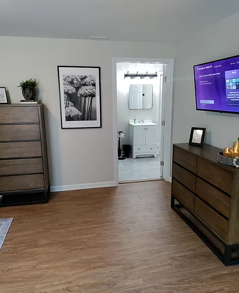 Two dressers in the bedroom with access to the bathroom.