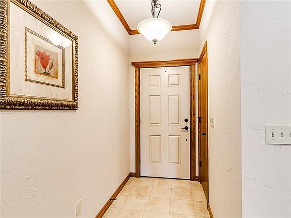 Foyer with crown molding and ceramic tile.