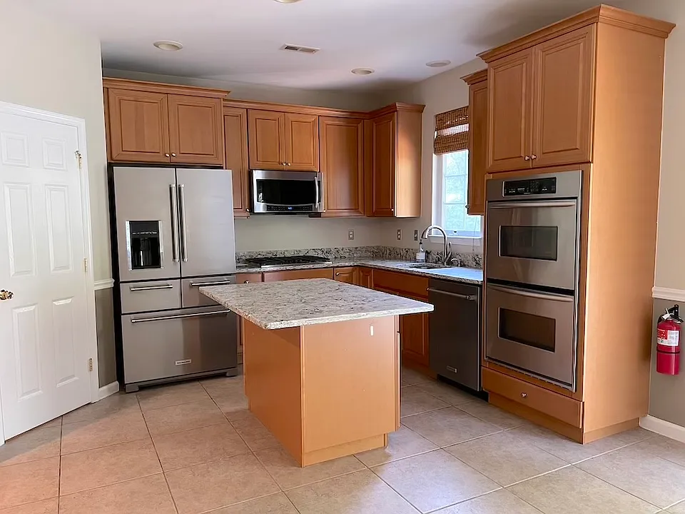 Kitchen with window center isle, double oven, Microwave and cooktop.