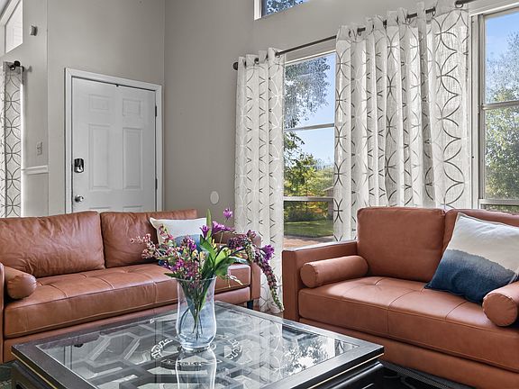 bright living room with big windows , leather sofa set