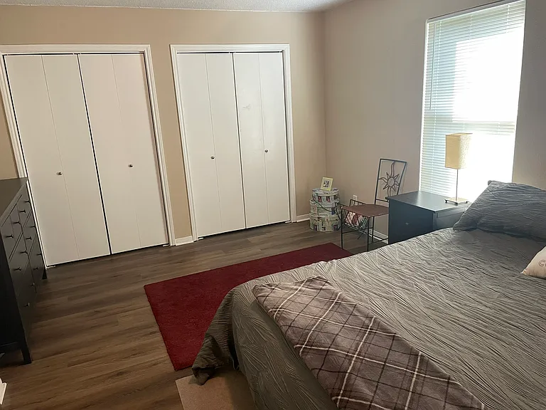 Large primary bedroom with double closet doors and ample space for desk/office nook.