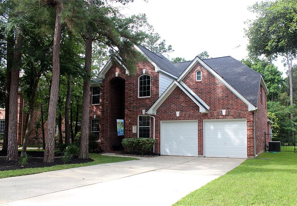 Beautiful landscaped and heavily treed front elevation of home.
