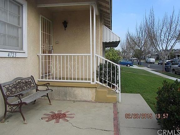 Front porch area features security screen door and safety hand rail.
