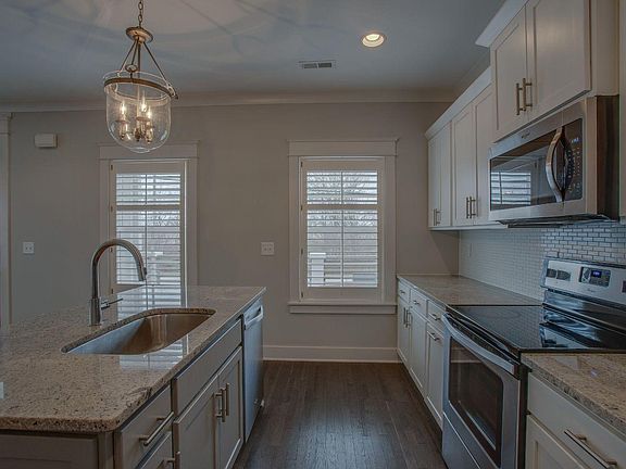 Living room view of kitchen and louvered windows. Kitchen area 9x13 approximately.