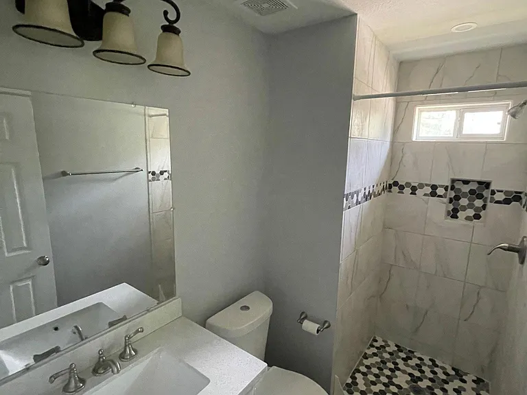 Upstairs bathroom with quartz vanity, shower and high end finishes