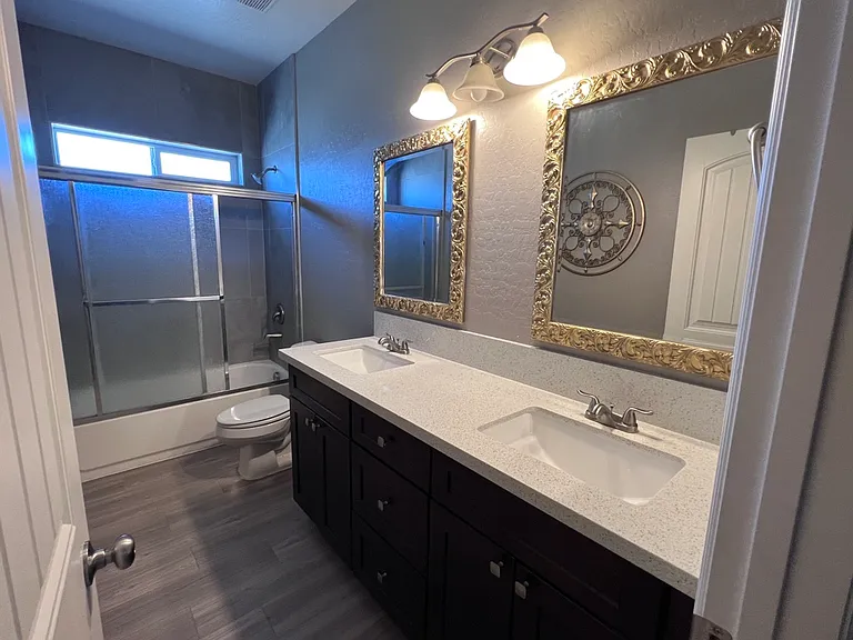 Bathroom with shower tub and double sinks.