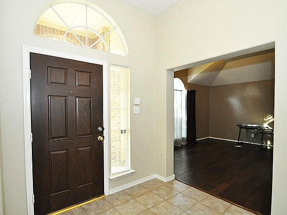 Entry with tile floors, looking into the formal dining room.