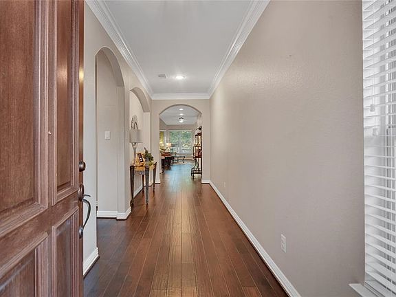 Long, grand entry foyer with beautiful hardwoods and art niche.