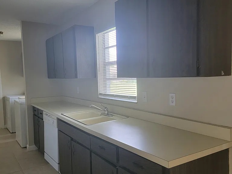 Kitchen Sink window looks out to backyard. Full-sized dishwasher