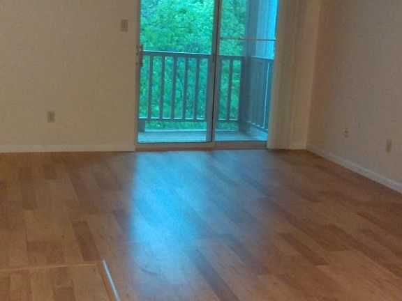 Living room with balcony overlooking beautiful foliage