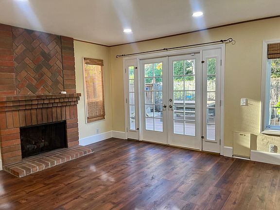 spacious family room with cozy fireplace and french doors open to scenic backyard