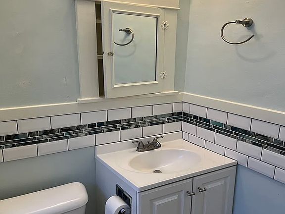Newer sink, cabinet and ceramic accent tile.
