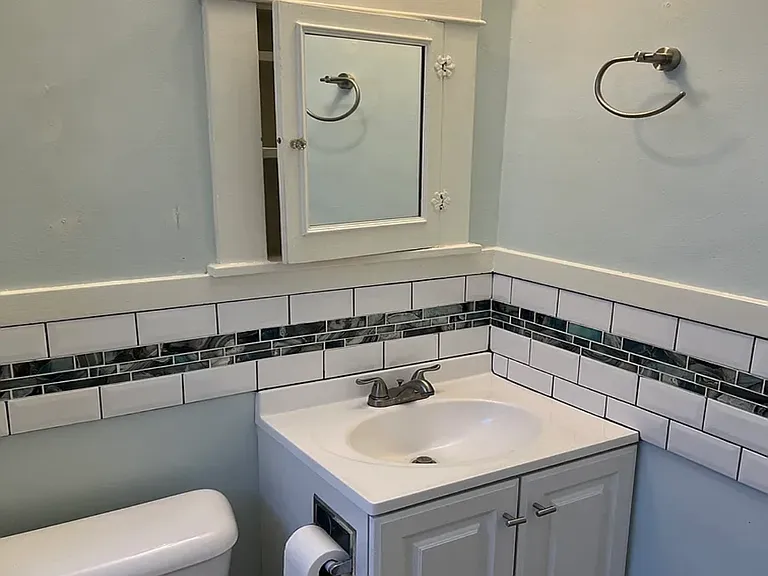 Newer sink, cabinet and ceramic accent tile.