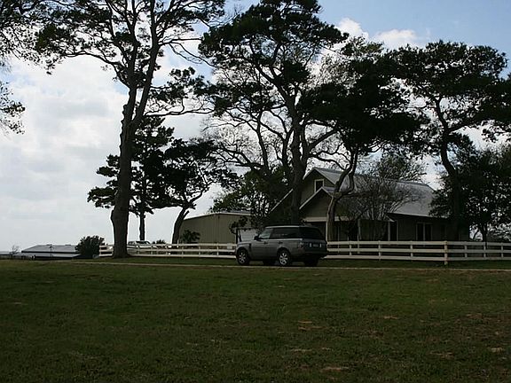 Ranch house with barn to left.  Barn holds exercise room/office and walk in deep freezers and cooler.