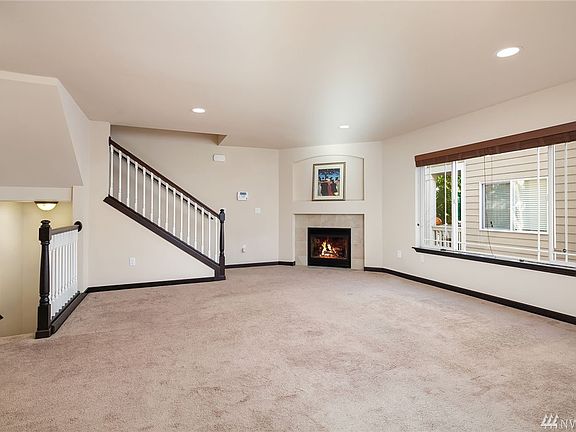 Main floor living room with cozy gas fireplace partial views of Cascade Mountains.