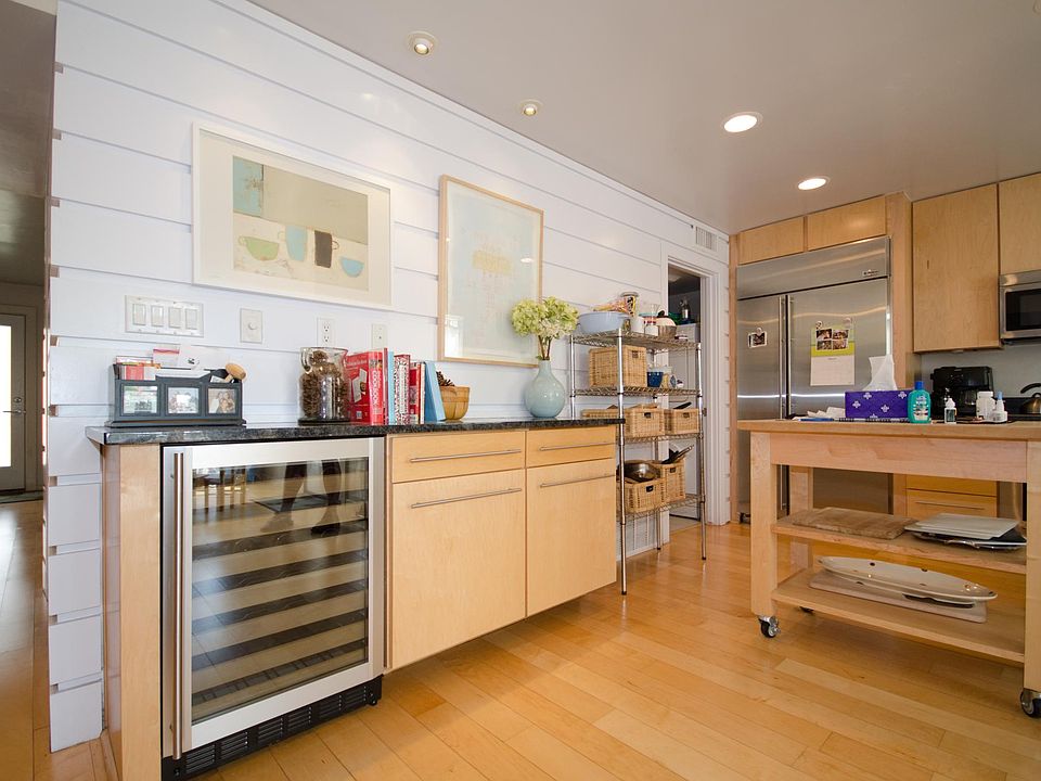 Custom home quality kitchen with bar/wine fridge, maple butcher block island, and built-in stainless appliances