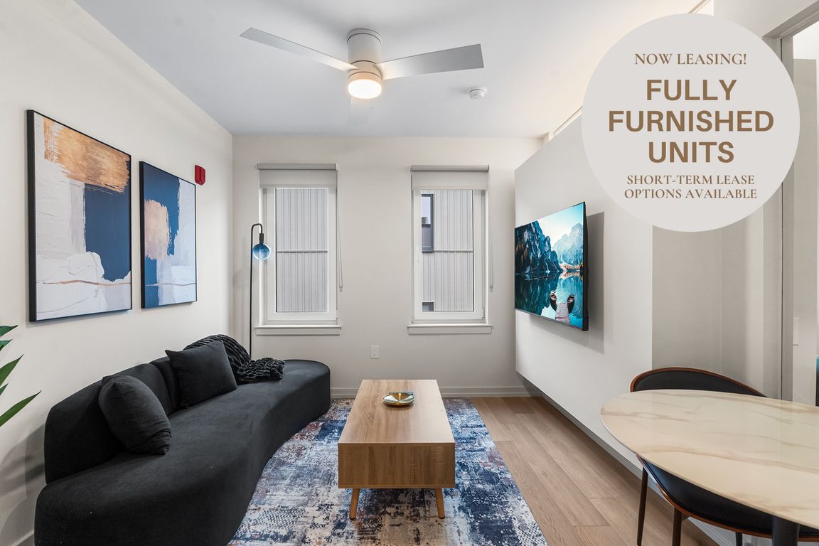 Living room with furnishings like couch, TV, coffee table, and dining table