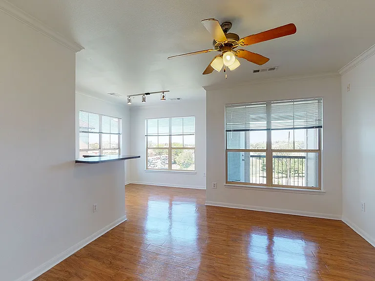 Apartment dining and living room with wood-style flooring.