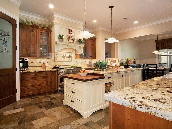 This exquisite island kitchen has everything you need! Granite countertops, farmhouse sink, Viking stove, pot filler, pendant lighting, large pantry and tile floor.
