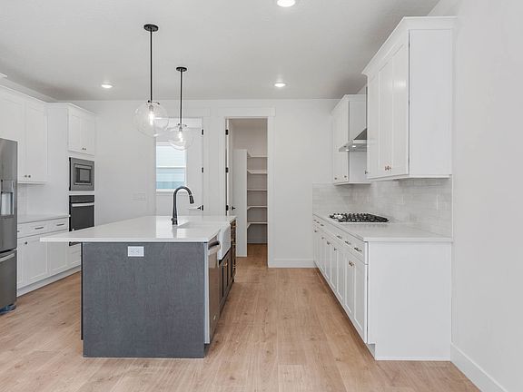 The kitchen of the Roan has beautiful white cabinets and sprawling quartz countertops.