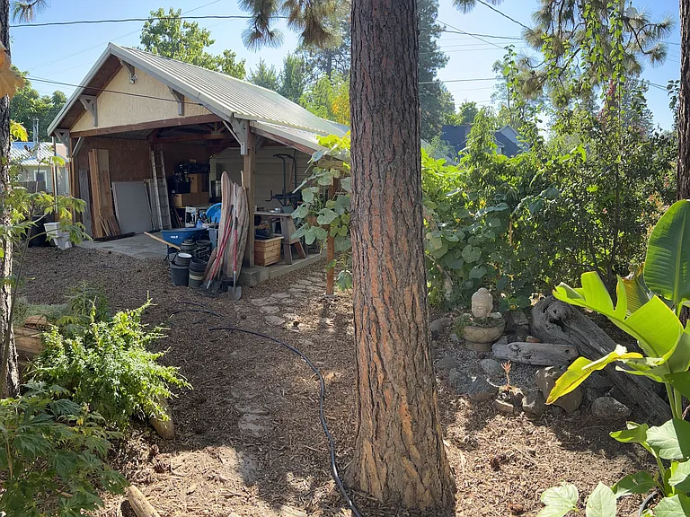 View of the back yard and garage with oversized awning.